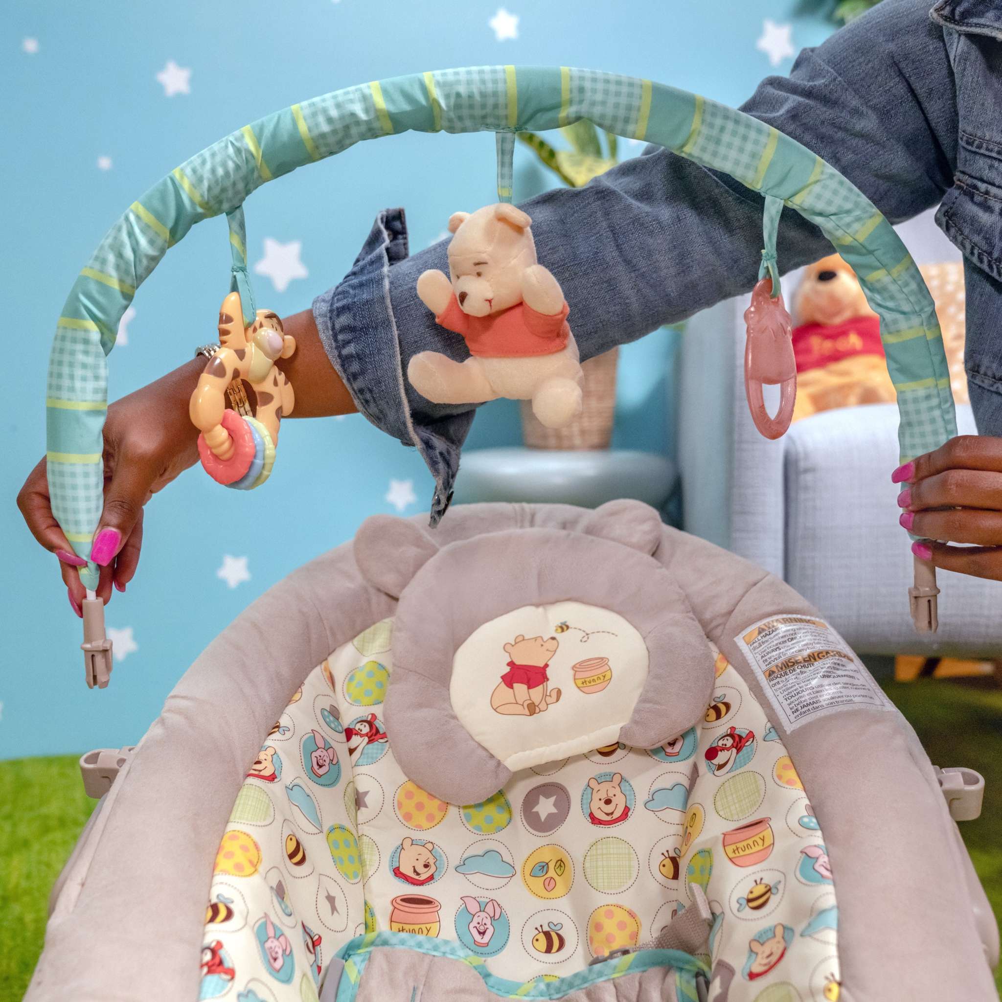 Winnie the Pooh baby bouncer with plush toys and colorful cushioned seat for infants.