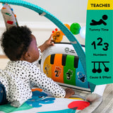 Baby using Baby Einstein 4-in-1 Kickin’ Tunes Music & Language Discovery Gym for tummy time with colorful piano and toy bars.