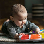baby playing with a glow & discover light bar activity station