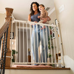 White metal Ingenuity Stairway+ 46W Series baby gate installed at top of stairs.