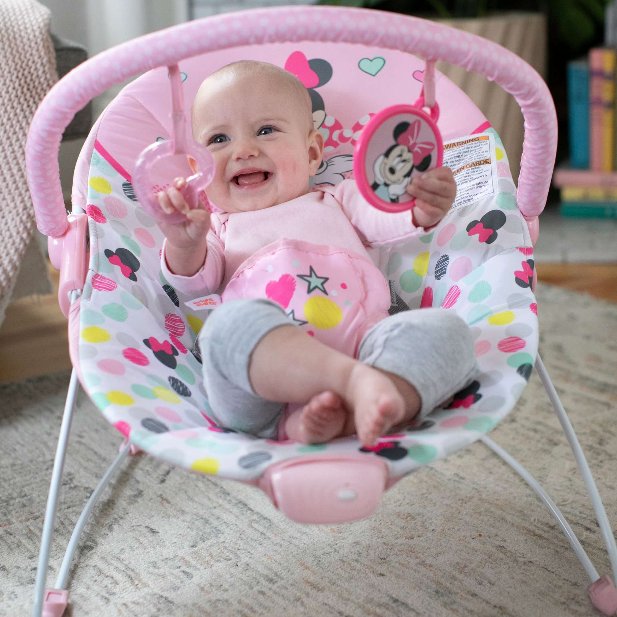 Minnie Mouse Spotty Dotty Vibrating Bouncer for Babies with toy bar and polka-dotted design.