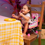 MINNIE MOUSE Pop ‘N Sit™ Portable Booster Seat with child at table, secure and compact design.