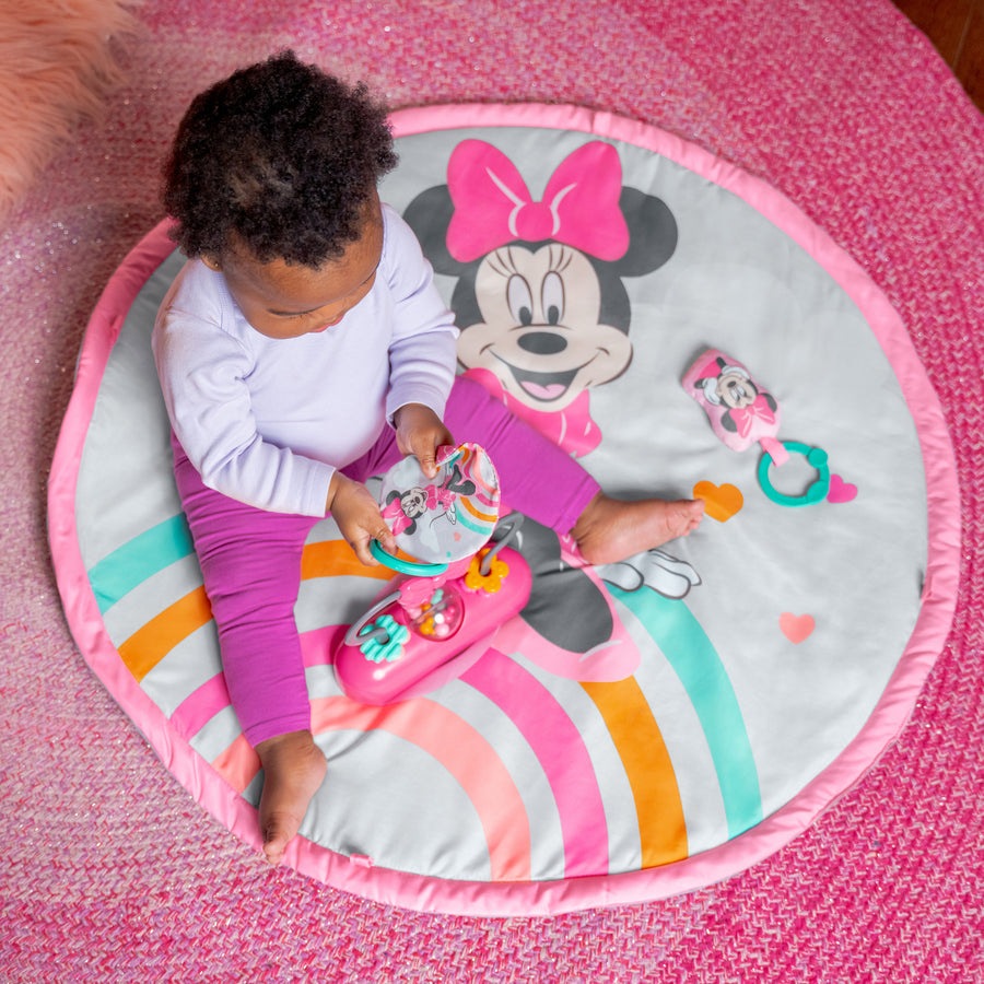MINNIE MOUSE Forever Besties Activity Gym with baby on colorful pink and rainbow mat featuring Disney's Minnie Mouse design.