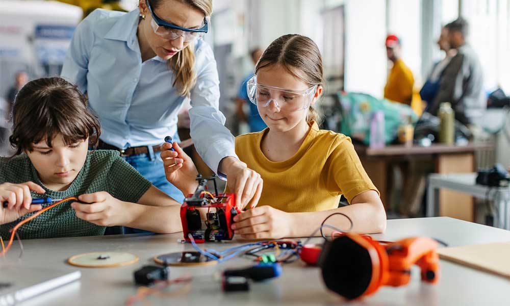 teacher helping to girls working 