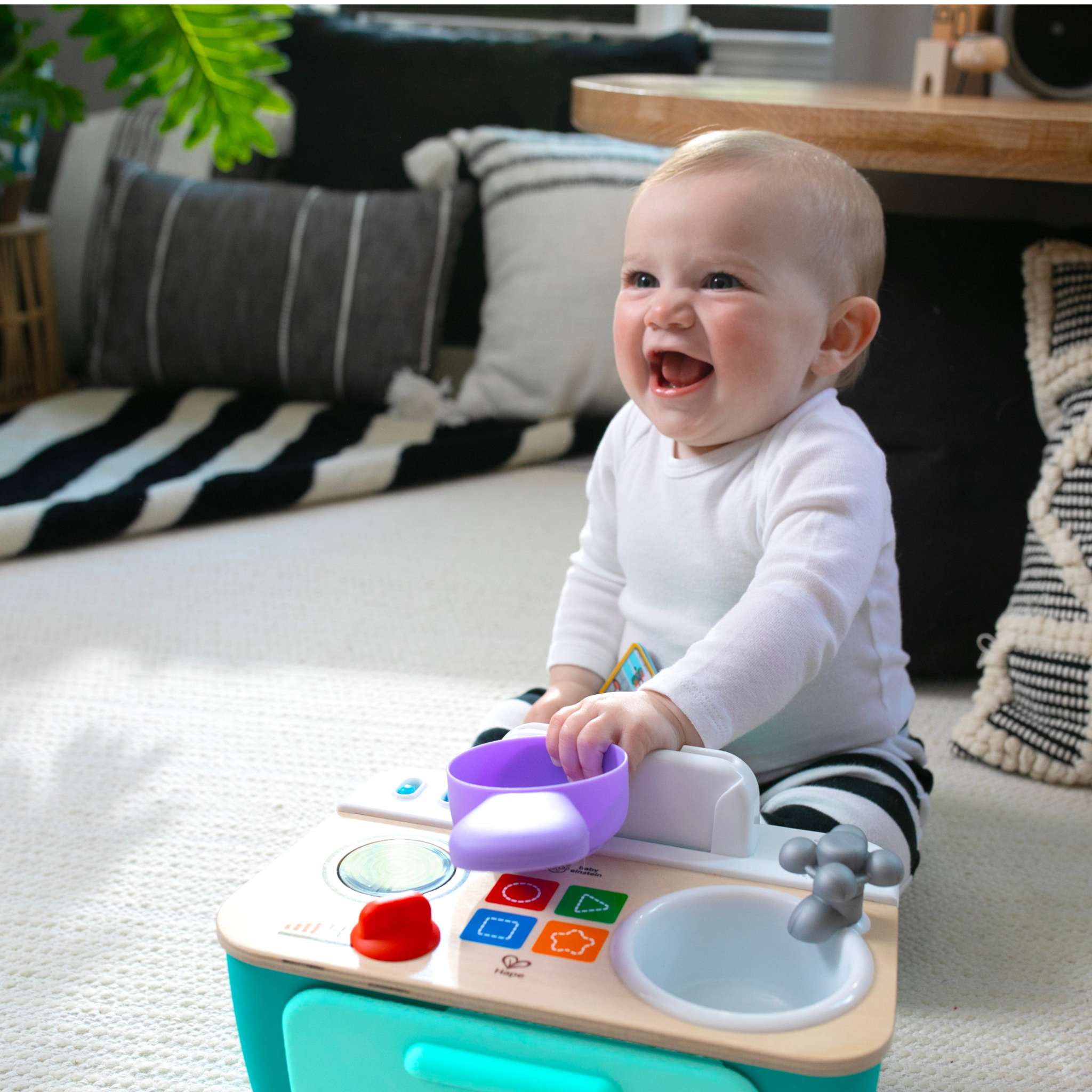 Baby playing with interactive language development toys from Baby Einstein, Bright Starts, and Ingenuity to support early speech and communication skills