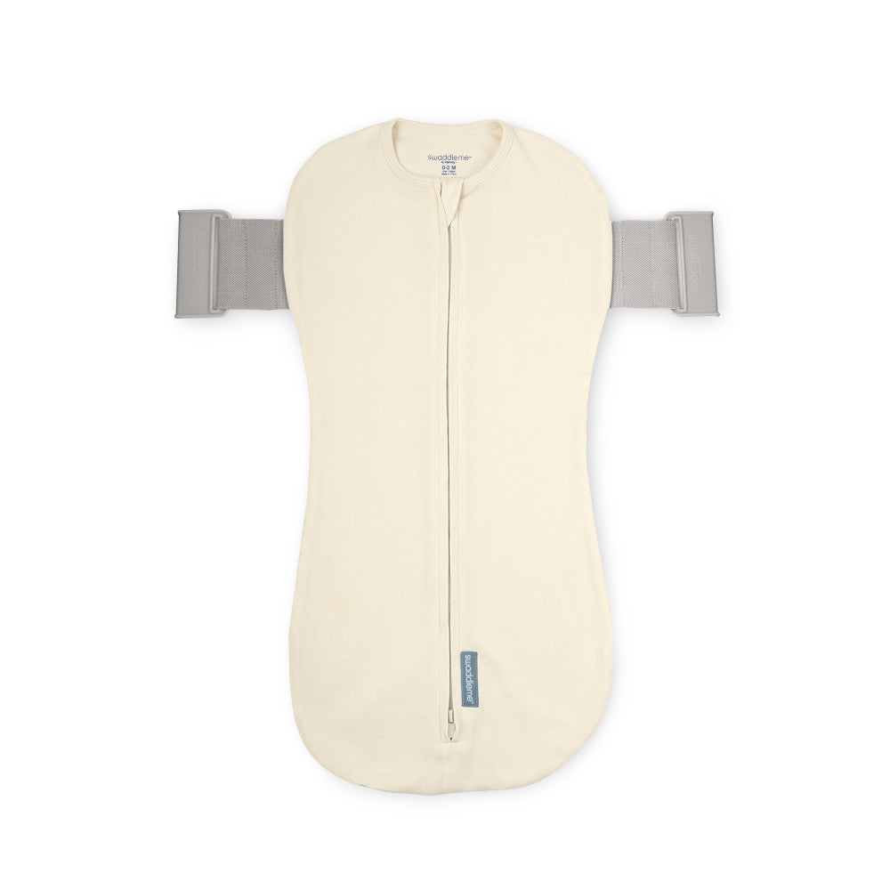 Cream-colored baby swaddle with gray straps on a white background