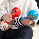 Baby holding Baby Einstein Jingle & Jam musical maracas toys for sensory and motor skill development