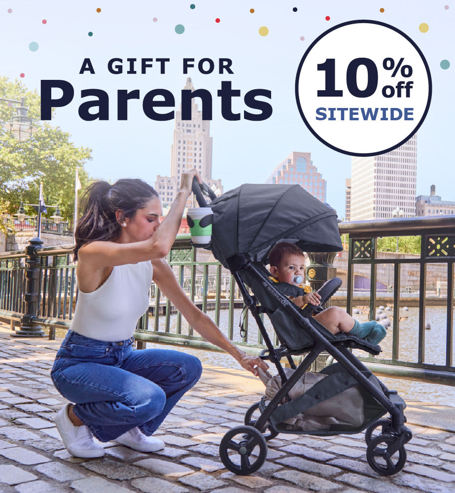 A woman crouches beside a black stroller on a waterfront walkway, with a child seated inside. Large promotional text reads 'A GIFT FOR Parents' and '10% off sitewide,' with a city skyline and railing in the background.
