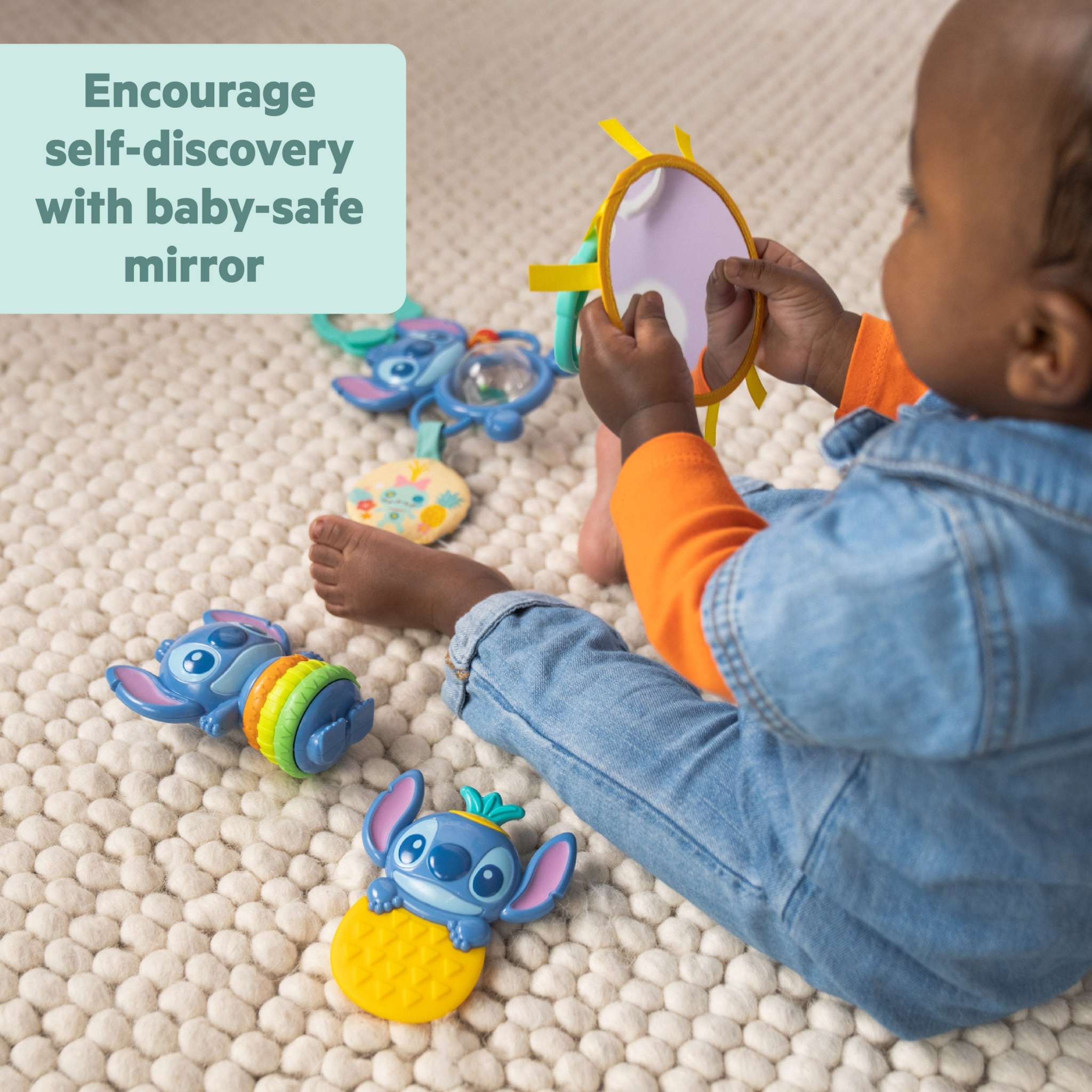 Baby playing with Disney Baby Stitch Tropical Treasures Gift Set featuring Stitch toys and baby-safe mirror