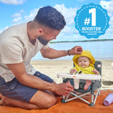 father with baby in a pop ‘n sit portable booster seat