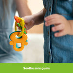 Baby holding Bright Starts Catch Me Smile gift set teething keys for soothing gums