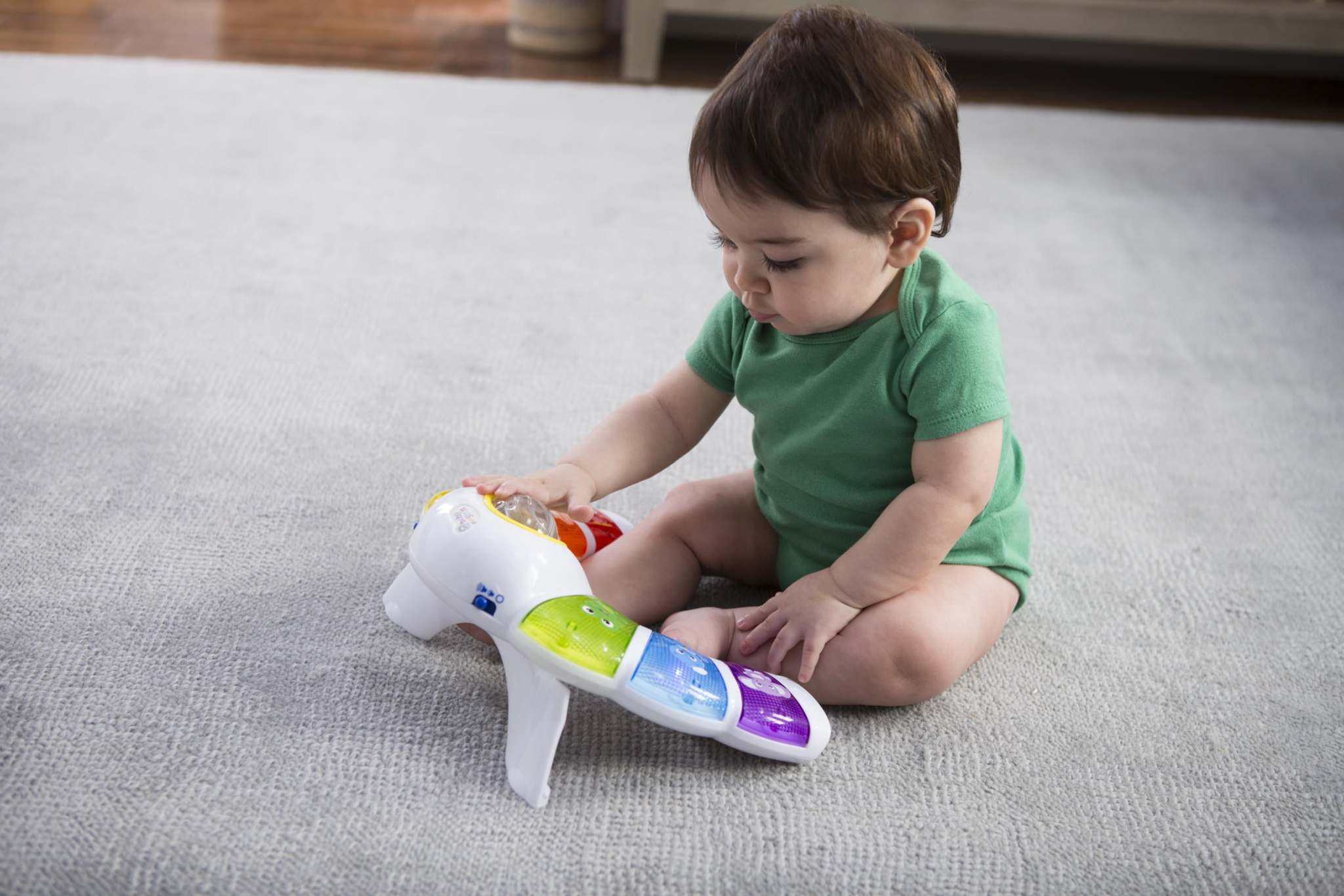 baby playing with a glow & discover light bar activity station