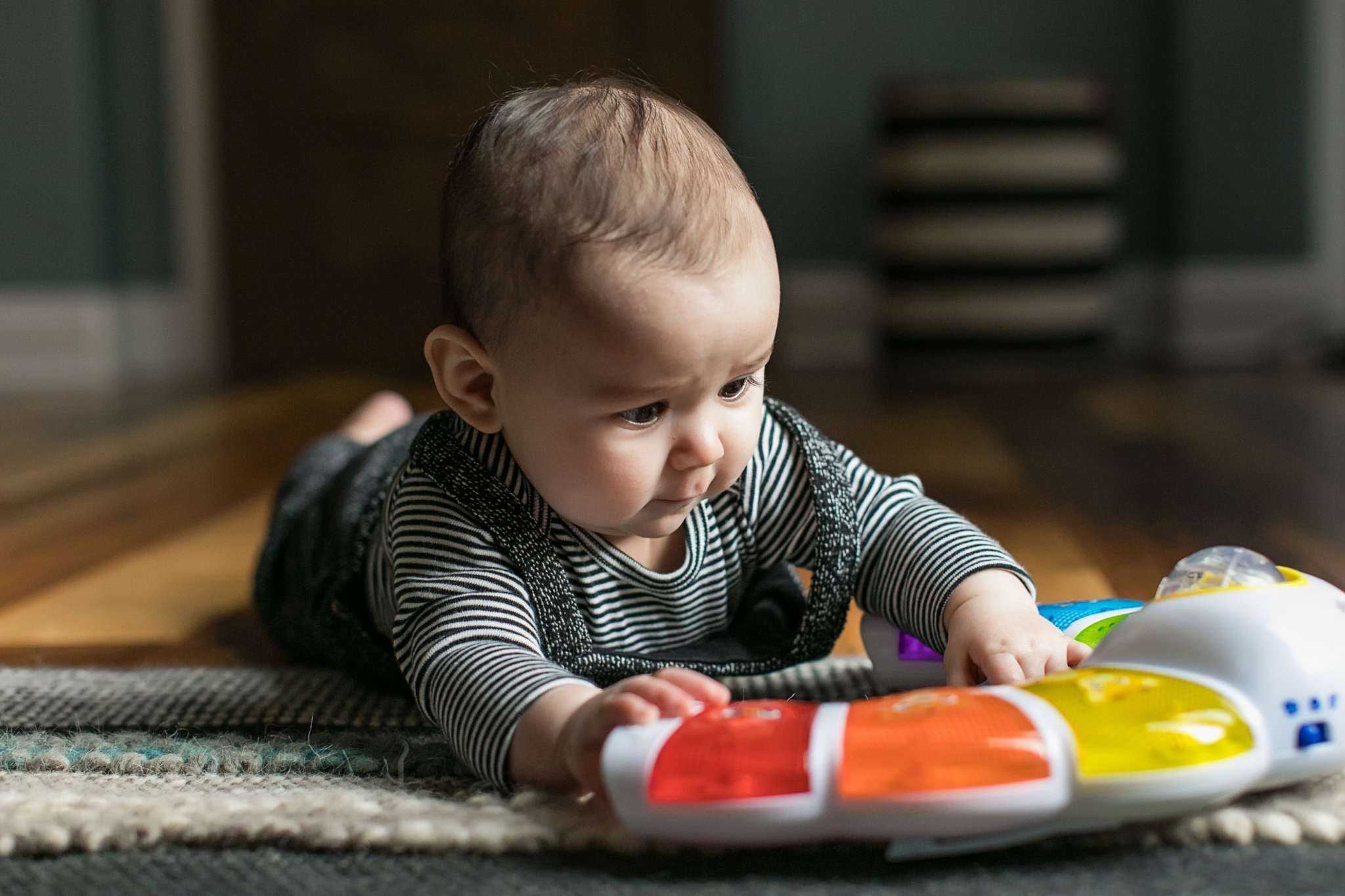 baby playing with a glow & discover light bar activity station