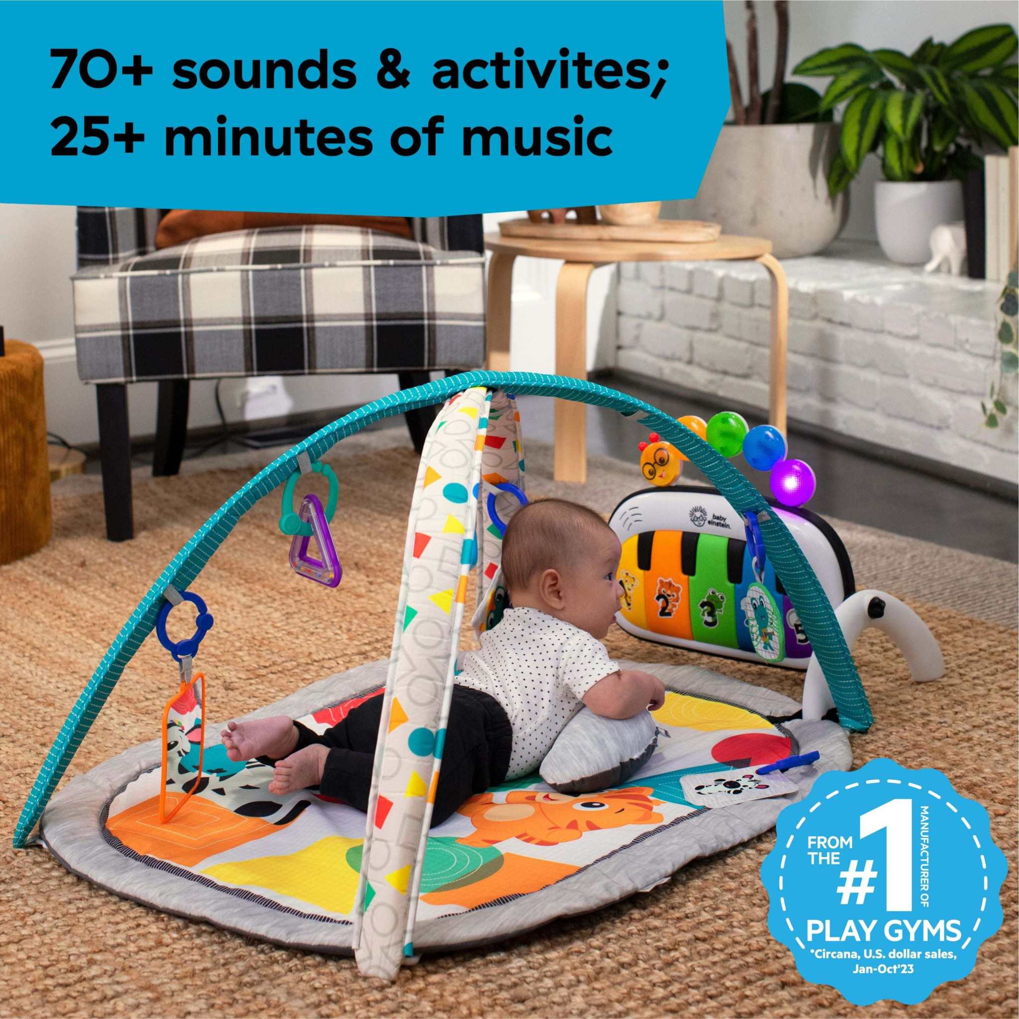 Baby playing on Baby Einstein 4-in-1 Kickin’ Tunes Music & Language Discovery Gym with colorful mat and toy bars in living room setting.