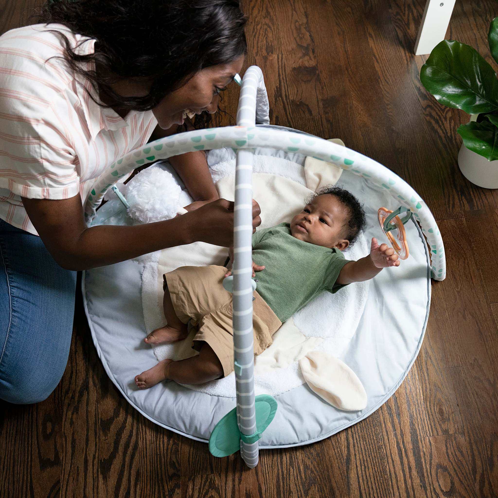 baby in a sheppy’s spot plush activity gym - corrie